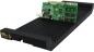 Preview: The image displays an elongated, black cooler with grooves and a green computer component resting on top. The card features black and silver components and shiny connections.
