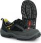 Preview: The image shows a pair of black sports shoes with yellow and gray accents. The sole is grippy and heavily treaded, ideal for outdoor activities. The shoe has a laced front.
