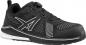 Preview: Ein schwarzer Sportschuh mit atmungsaktivem Netzmaterial und reflektierenden Details. Er hat eine kunststoffene Zehenkappe und eine moderne Schnürung mit einem Drehverschluss.