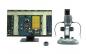 Preview: In the image, on the left there is a monitor displaying a close-up of a circuit board, and on the right a microscope with several connections and a sturdy base.
