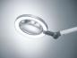 Preview: The image displays a magnifying lamp with a round, transparent glass and an integrated ring of light. The arm is flexible and allows for various positions.