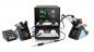 Preview: The image shows a soldering station with a control unit and two soldering tips. The control unit has a display with temperature readings. Next to the unit, there are soldering tin and cleaning materials.