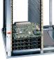 Preview: Das Bild zeigt einen vertikalen Computer-Rack mit mehreren grün gestrichenen Platinen. Die Platinen sind in einem Metallgehäuse gestapelt, versehen mit mehreren Anschlüssen und Steckplätzen.
