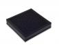 Preview: The image shows a square, flat object in black with a rough, textured surface. It has a matte finish and looks like a cushion or pad.