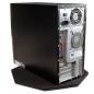 Preview: The image displays the casing of a computer. It is black with a silver back that features various ports and ventilation slots. The computer is situated on a plated base.