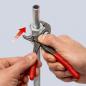 Preview: The image shows two hands, each holding a tool. One hand is using an adjustable wrench, while the other is holding a metal pipe with a nut.