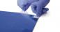 Preview: In the picture, you see a hand with blue gloves peeling a transparent film from a blue sheet. The surface is smooth and shiny.