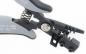 Preview: The image shows a pair of pliers with a curved, gray surface and a spring. The pliers have two jaws, one of which is equipped with a small trigger.