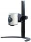 Preview: The image shows a compact projector with a white casing, mounted on a black, sturdy stand. The projector has control buttons on the front.