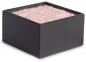 Preview: The image displays a square container with a smooth, black exterior. It is filled at the top with a pink, fluffy substance.