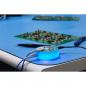 Preview: On a blue table lies a glowing, round adapter with cables. In the background, two green circuit boards are visible, equipped with various electronic components.
