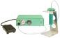 Preview: The image shows a medical device in soft green tones. It has a pressure gauge and a rotary knob. Next to the device, there is a foot pedal and a container on a metal stand.
