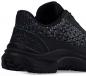 Preview: The image shows the rear part of a black sports shoe. The surface has a triangular pattern, and a light blue seam runs along the side. The sole is sturdy with good grip.
