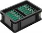 Preview: The image shows a black plastic box with two separate compartments. Each compartment contains green circuit boards equipped with small components. The box is sturdy and has a practical shape.