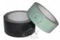 Preview: The image shows two rolls of tape. One roll is black, the other light green. Both have an empty inner core and are lying next to each other.