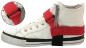 Preview: The image shows a white sneaker with a red securing strap. The strap wraps around the shoe to improve its grip. In the smaller image section, the strap can be seen in more detail.