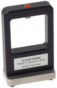 The image shows a rectangular device with an open frame, topped with a red button. It stands on a wide, stable base. A labeled metal plate is attached to the front.