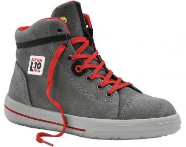 The shoe is a gray high-top sneaker with red laces. It has a sturdy, flat sole and a striking, sporty look. A logo is visible on the outside.