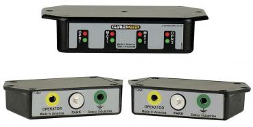 The image shows three black control boxes with colored buttons and glowing LEDs. At the top is a larger box with two control indicators, below are two smaller boxes with various functions.