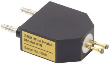 The picture shows a small, hexagonal, black mini-sensor with two metal pins on the top and a round connector on the bottom. A golden plaque bears the inscription 