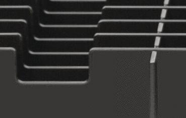 The image shows a close-up of a black, textured material with parallel grooves and sharp corners. The surface appears smooth and orderly.