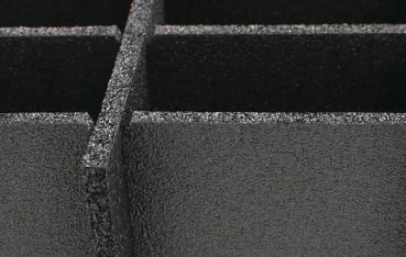 The image shows a black, textured surface with several rectangular indentations. The edges are sharply defined, conveying a sense of depth and dimension.