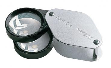 In the picture, there is a double magnifying glass that has two lenses: one for 4x and one for 6x magnification. The frame is black and silver. The lenses are clear and round.