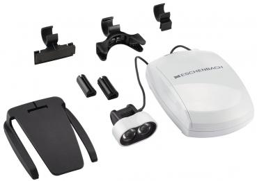 The image shows a set of magnification aids. It includes an electric magnifier, various mounts and attachments in black and white, all neatly arranged.