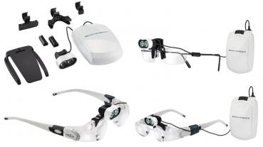 The image shows a set of magnification aids. It includes an electric magnifier, various mounts and attachments in black and white, all neatly arranged.