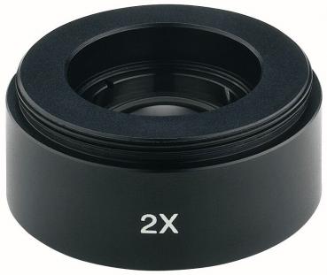 The image displays a black lens or objective with the label "2X". It features a circular shape with a slightly protruding glass in the center and a matte edge.