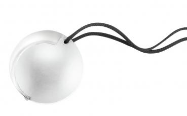 The image displays a round, flat object in soft, light colors. It has a slightly curved surface and a small indentation on the side. It might be a lid or a cover.