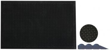 The image shows a large, black mat with many small bumps in a uniform pattern. Next to it is a small round mat and a triangular element, also in black.