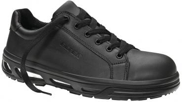 The shoe is black, made from smooth material with a padded tongue. It has a sporty design, laces, and a textured, non-slip sole.