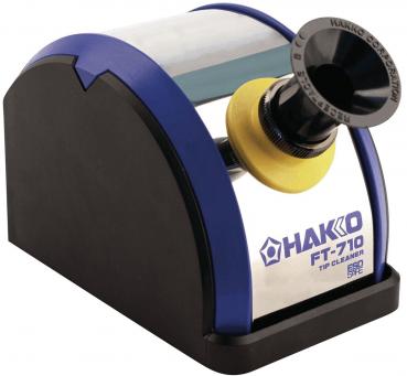The image displays an electric tip cleaner. It features a rounded black base, a transparent lid, and a circular opening with a yellow border. The brand 