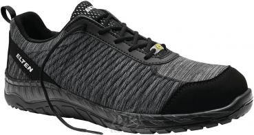 Der Schuh ist schwarz mit grauen, strukturierten Bereichen. Er hat eine bequeme, niedrige Form, eine Schnürung und eine rutschfeste Sohle. Ideal für Alltag und leichte sportliche Aktivitäten.