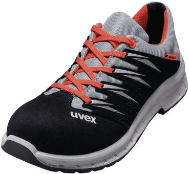 Der Schuh ist sportlich und leicht. Er hat ein schwarzes Obermaterial mit orangen Schnürsenkeln und silbernen Akzenten. Die Sohle ist stabil und bietet guten Halt.