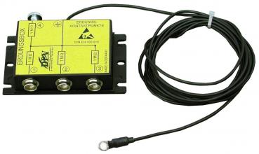 The image displays a black grounding box with three terminals. On the top side, there is a yellow label with symbols and text. Adjacent to the box, there is a black cable with a round connector.
