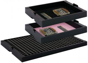 The image shows a rectangular, flat box made of dark cardboard. The corners are folded up, and it has a textured surface. It is open and empty.