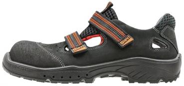 The shoe is black with orange accents. It has a round, reinforced toe cap, a non-slip sole, and laces. The surface features some texture details and ventilation elements.