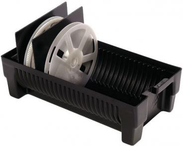 The image shows a black container with four round, white plates. One of the plates is tilted and two black dividers stand in the box. The structure is functional and simple.