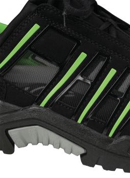 The image displays a section of a black athletic shoe with green accents. The sole is sturdy and textured, while the upper appears breathable with slight reflections.