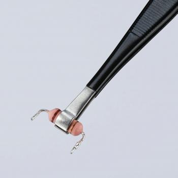 The image shows a pair of pliers with a black handle. At the end, there is a silver metal clamp with two small pink rubber balls that form a flexible structure.