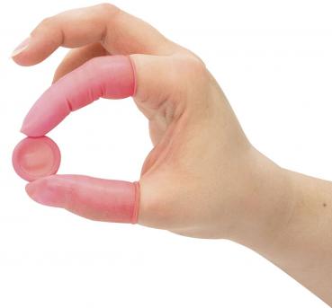 Eine Hand mit langen, pinken Fingerlingen hält eine kleine runde, ebenfalls pinke Scheibe zwischen Daumen und Zeigefinger. Die Hand ist leicht geöffnet.