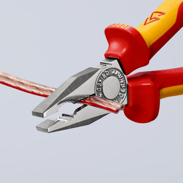 Das Bild zeigt eine Zange mit roten und gelben Griffen, die einen kupferfarbenen Draht festhält. Die Zangenbacken sind metallisch und ausgefeilt, um präzise zu greifen oder zu schneiden.