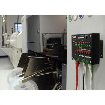 The image shows a technical environment with a device named "Ground Master". It has numerous green LEDs and connection cables in various colors. To the left, a larger machine is visible.