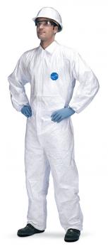 A person stands upright in a white protective suit, with blue gloves and a white helmet. They have their hands on their hips and are looking forward.