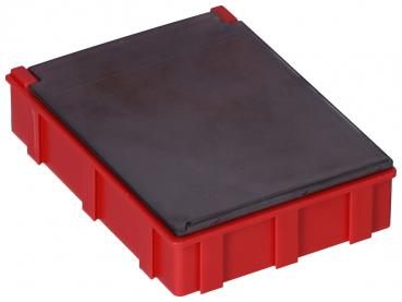 Das Bild zeigt eine rechteckige Box, die rot ist mit einer glänzenden schwarzen Oberseite. Sie hat grobe Kanten und eine leicht strukturierte Oberfläche. Die Box ist flach und kompakt.