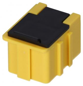 Das Bild zeigt einen kleinen, rechteckigen Kunststoffstecker in gelber Farbe mit einem schwarzen Deckel oben. An den Seiten sind kleine Ausbuchtungen sichtbar.