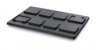 Das Bild zeigt eine schwarze Kunststoffplatte mit mehreren erhabenen rechteckigen und quadratischen Formen, die beschriftet sind. Die Formen sind unterschiedlich angeordnet und haben verschiedene Größen.