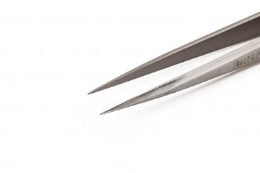 The image shows a sharp metal scissors with long, narrow blades. The silver surface lightly reflects the light. It is lying on a white background.